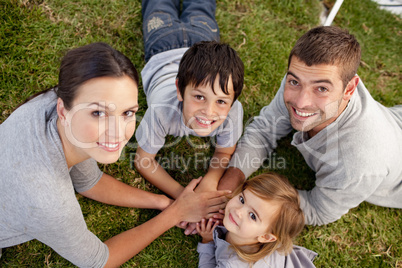 Happy parents and kid lying on garden