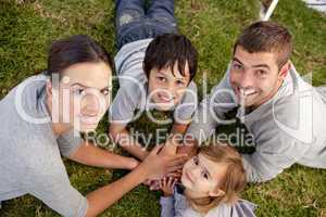 Happy parents and kid lying on garden