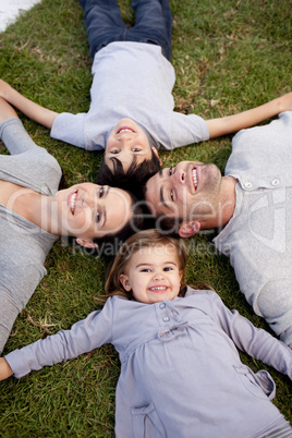 Family lying in a garden with heads together
