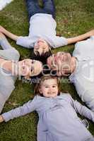 Family lying in a garden with heads together