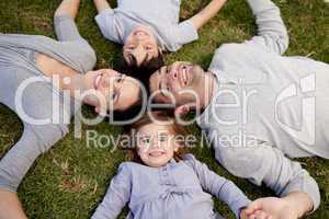 Little girl lying in a park with her parents and brother