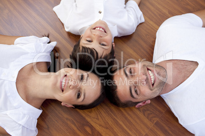 Parents and kid lying on floor with heads together