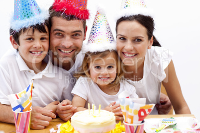 Family celebrating daughter's birthday at home