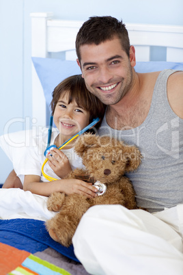 Father and son playing doctors in bed