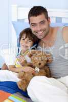 Father and son playing doctors in bed