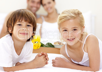 Portrait of children in bed with their parents