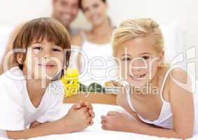 Portrait of children in bed with their parents