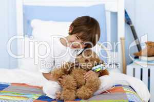 Little boy playing with headphones and teddy bear