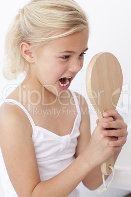 Little girl having fun with a mirror