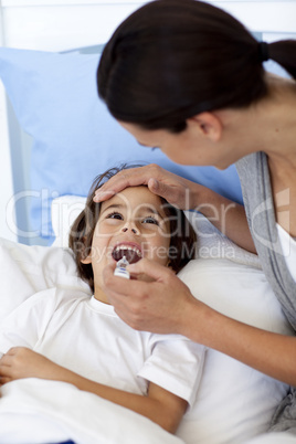 Portrait of mother taking her son's temperature