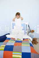 Little boy listening to music and dancing in bedroom