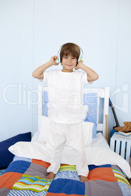 Little boy with headphones on dancing in bedroom