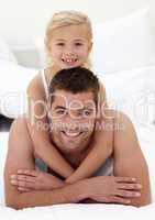 Father and daughter playing in bed