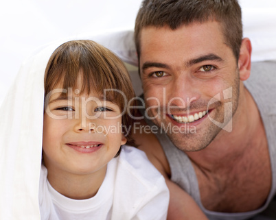 Father and son playing under the bedsheets