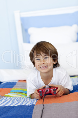 Smiling boy playing videogames in his bedroom