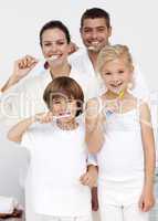 Parents and children cleaning their teeth in bathroom
