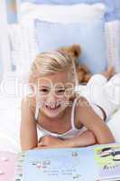 Little girl reading in bed