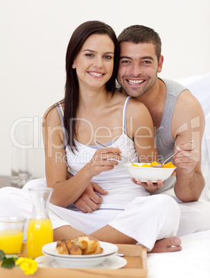 Couple having healthy breakfast in bed