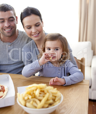 Little girl eating fries and pizza at home