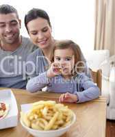 Little girl eating fries and pizza at home