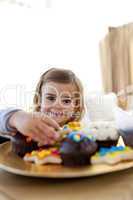 Smiling little girl eating confectionery at home