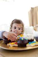 Hungry little girl looking at confectionery at home
