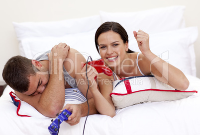 Couple playing videogames in bed