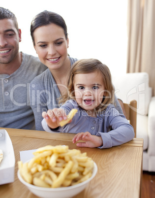 Little girl eating fries at home