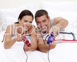 Couple having fun playing videogames in bed