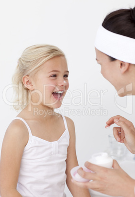 Mother and daughter having fun with cream