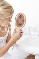 Little girl playing with a mirror