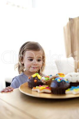 Little girl looking at confectionery at home