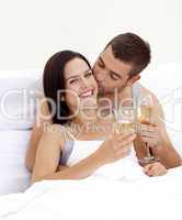 Couple drinking champagne in bed in valentine's day