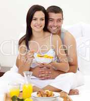 Wife and husband having nutritive breakfast in bed