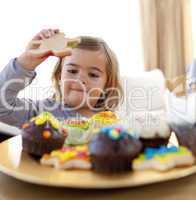Happy little girl eating confectionery at home