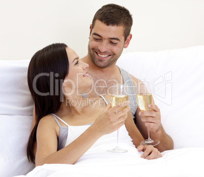 Couple drinking champagne in bed