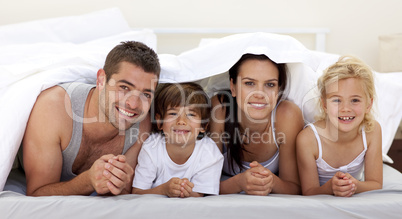 Family playing in parent's bed