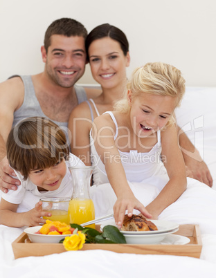 Family eating breakfast in bedroom