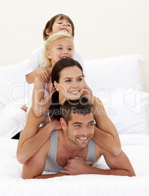 Family climbing on top of each other in bed