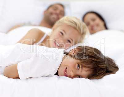 Family resting in parent's bed