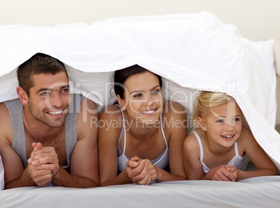 Parents and daughter under the sheets