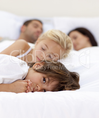 Little boy relaxing with his parents and sister sleeping