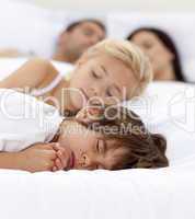 Family sleeping in parent's bed