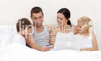 Family buying online in bed