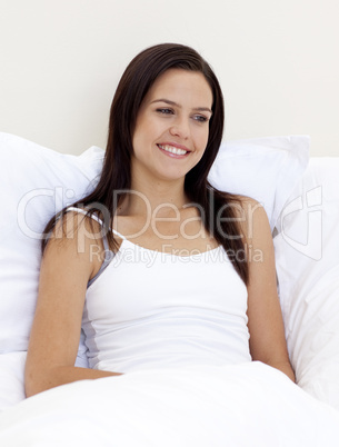 Smiling woman relaxing in bed
