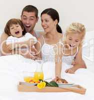 Family having breakfast in bed in the morning