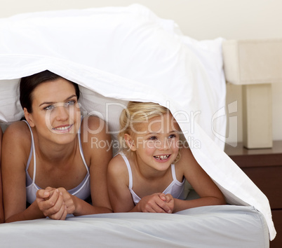 Mother and daughter under the sheets
