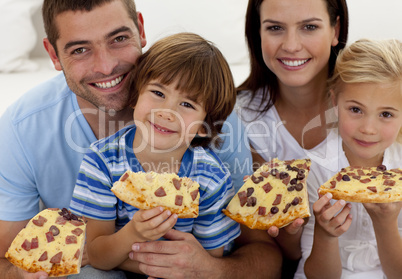 Portrait of family eating pizza on sofa