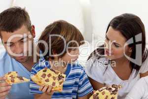 Parents and son eating pizza in living-room