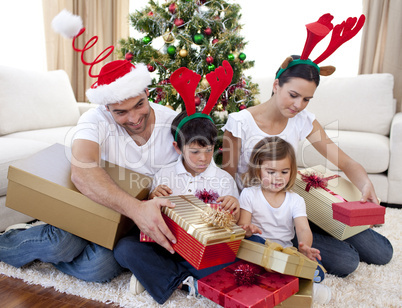 Happy family opening Christmas presents at home